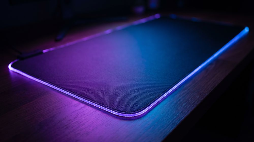 Mousepad grande com borda RGB roxa e azul iluminada, estilo Nerdesk
