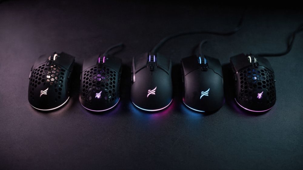Cinco mouses gamer leves em fileira com iluminação RGB roxa e azul, estilo Nerdesk