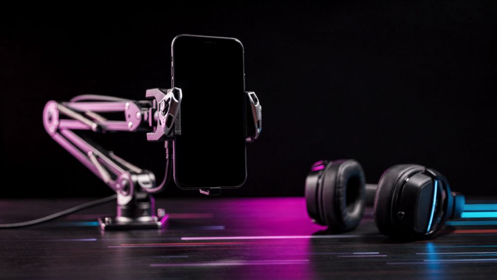 Setup mobile profissional com smartphone em suporte articulado e iluminação RGB, estilo Nerdesk