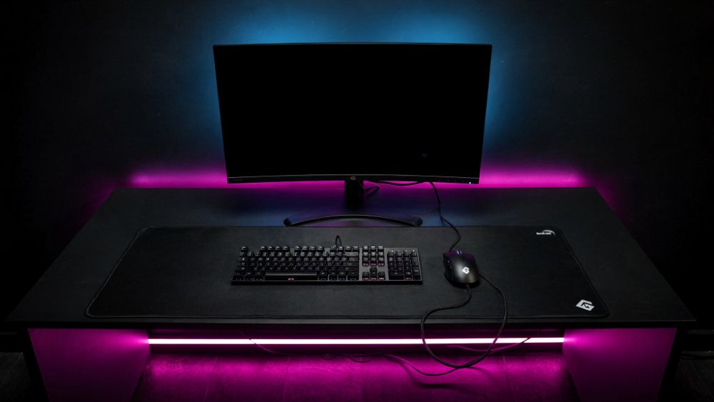 Estação de e-sports CS2/Valorant com iluminação RGB roxa e azul, estilo Nerdesk