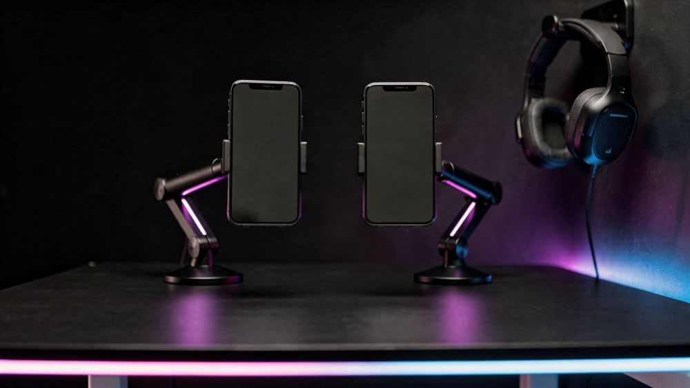 Setup mobile competitivo com dois smartphones em suportes articulados e headset, estilo Nerdesk